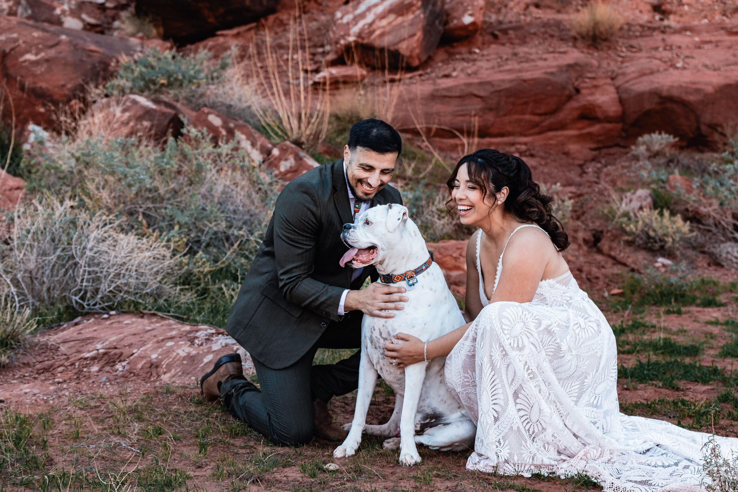 Couple loving on their dog during portraits after their Malboro Point elopement ceremony in Moab.
