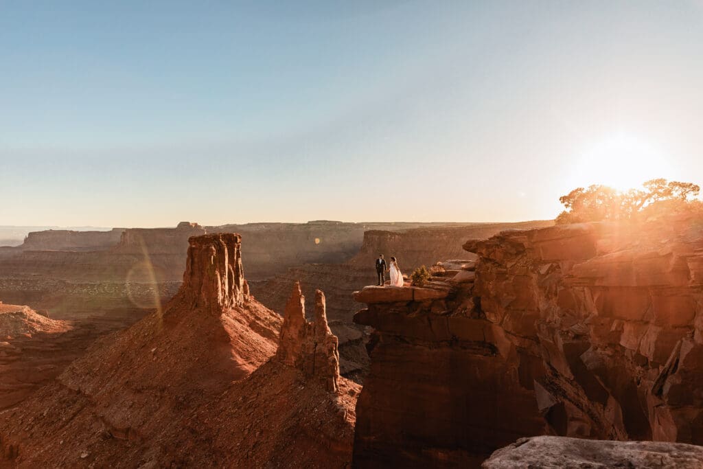 An intimate elopement at Marlboro Point in Moab, Utah, as golden sunset light washes over the canyon and desert cliffs.