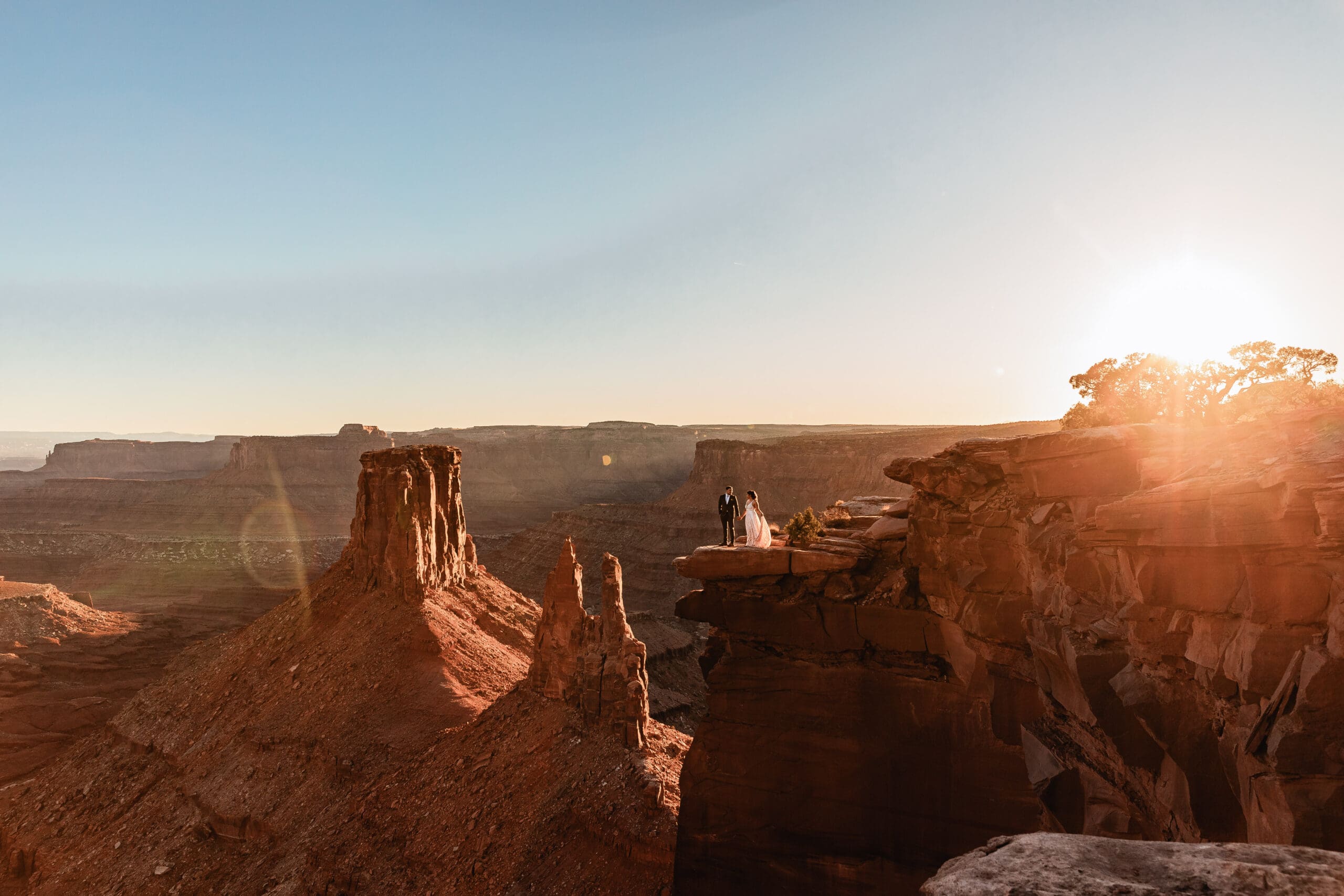 An intimate elopement at Marlboro Point in Moab, Utah, as golden sunset light washes over the canyon and desert cliffs.