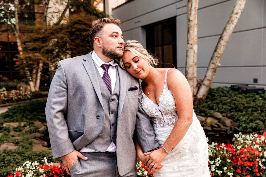 Bride resting her head on her husband’s shoulder during Pittsburgh Airport Marriott portraits