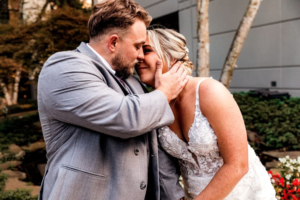 Groom brushing bride’s hair away during portraits at Pittsburgh Airport Marriott