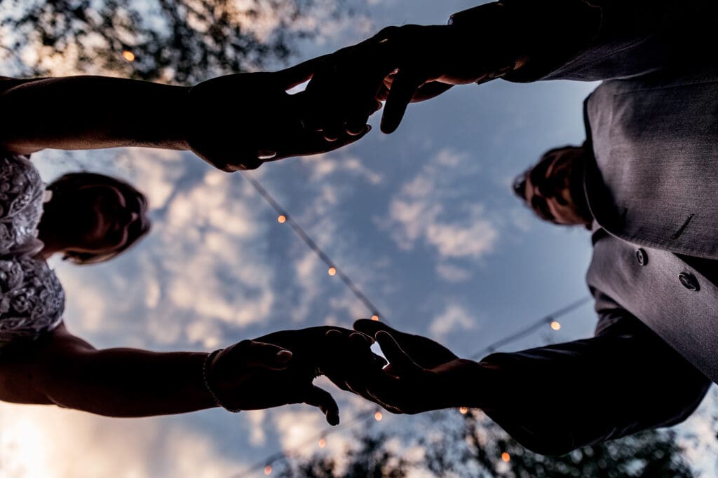 Bride and groom holding hands with sunset in the background at Pittsburgh Airport Marriott