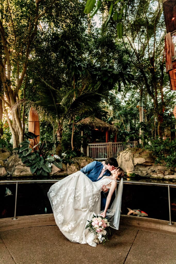 Pittsburgh bride and groom sharing a dip kiss in front of the coy pond at Phipps Botanical Gardens