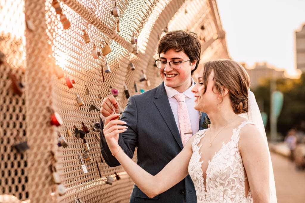 Pittsburgh bride and groom adding their lock to the Locks of Love bridge at golden hour in Phipps Botanical Gardens