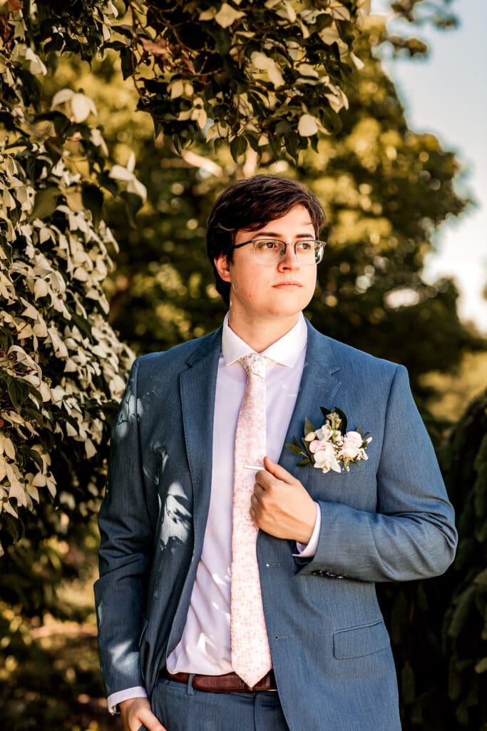 Pittsburgh groom standing under a Dogwood tree during outdoor wedding portraits at Phipps Botanical Gardens