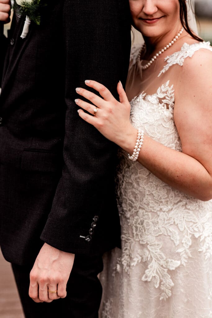Close up of bride and groom’s wedding bands during their Lingrow Farm wedding