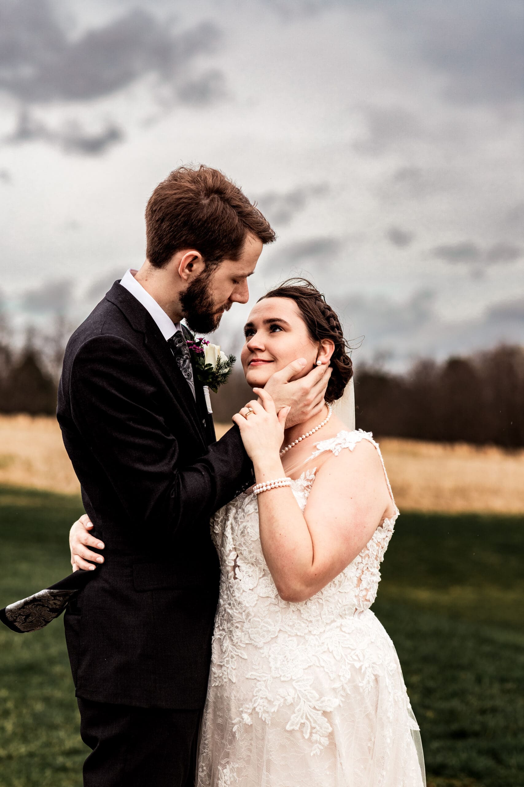Groom gently cupping bride’s face during their wedding at Lingrow Farm