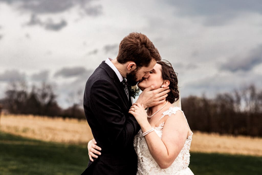 Bride and groom sharing a romantic kiss during their Lingrow Farm wedding