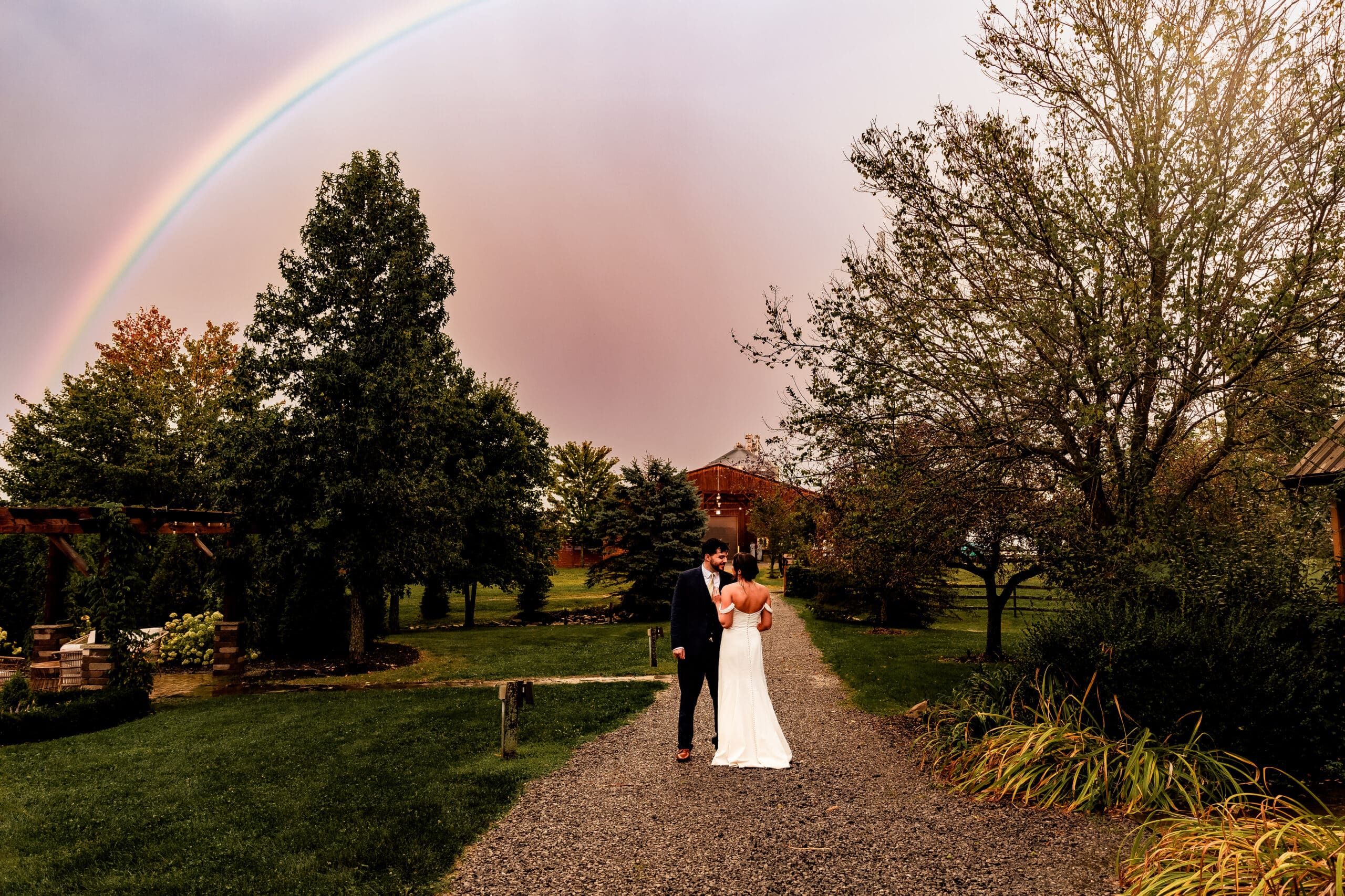 Bride and groom embrace beneath a rainbow during their Willowbrook wedding reception in Volant, PA