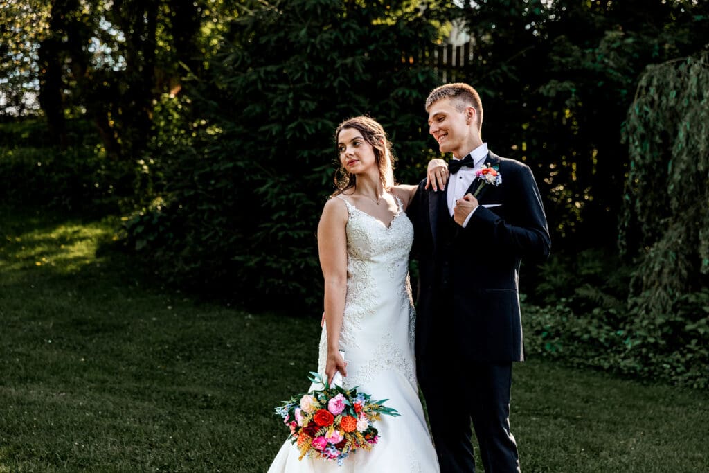 Couple stands together in a green garden setting during their Willowbrook wedding