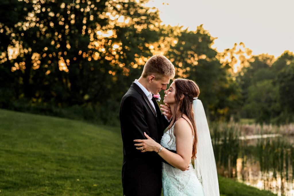 Couple poses on a grassy hill at sunset during their Willowbrook wedding