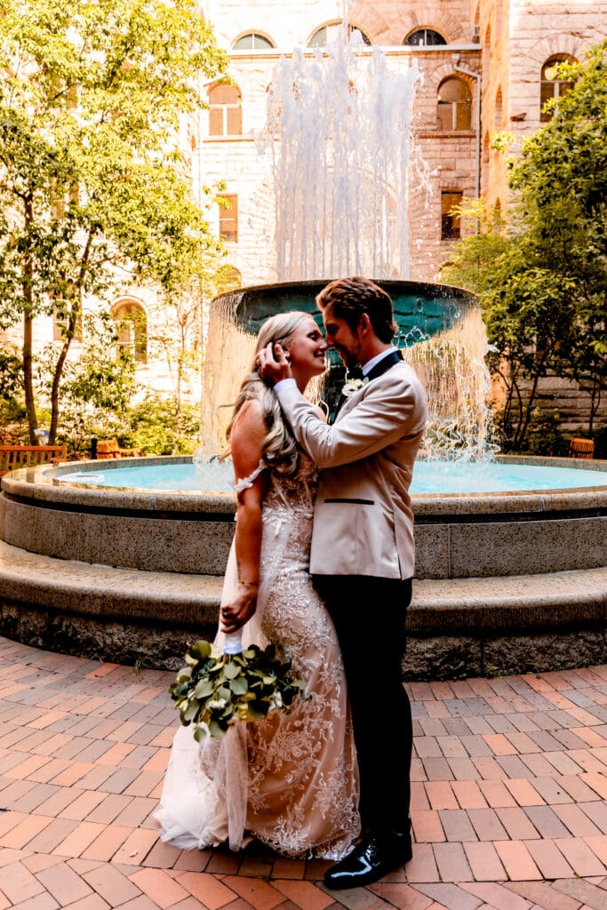Wedding couple kissing in front of the fountain at Allegheny County Courthouse