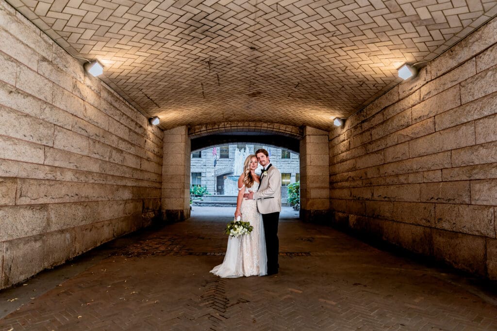 Wedding couple posing in the tunnel leading to the courtyard at Allegheny County Courthouse