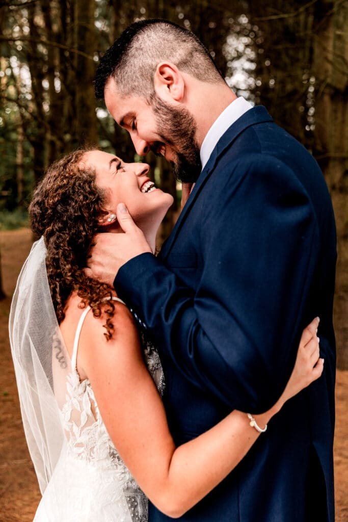 Wedding couple embracing in a pine tree grove during their Sanaview Farm wedding in Somerset, PA