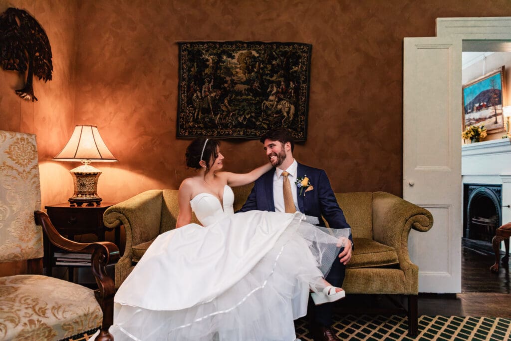 Couple relaxing on vintage couch in elegant lobby at Succop Nature Park wedding