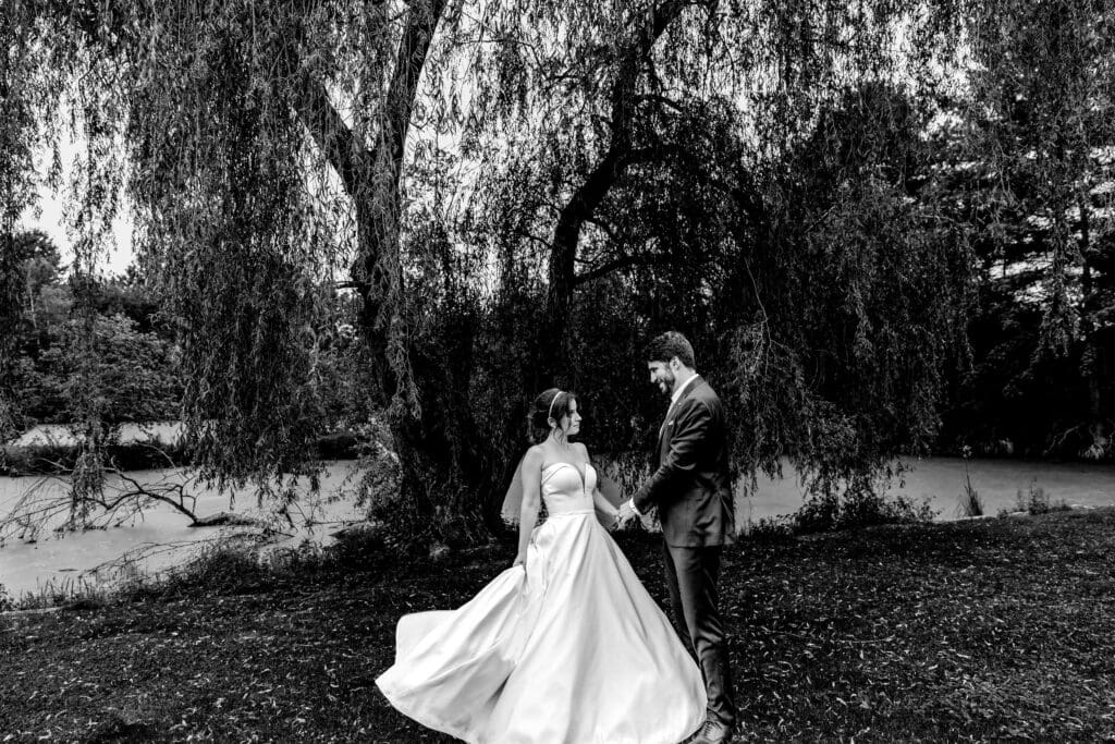 Black and white photo of couple dancing under willow tree at Succop Nature Park wedding