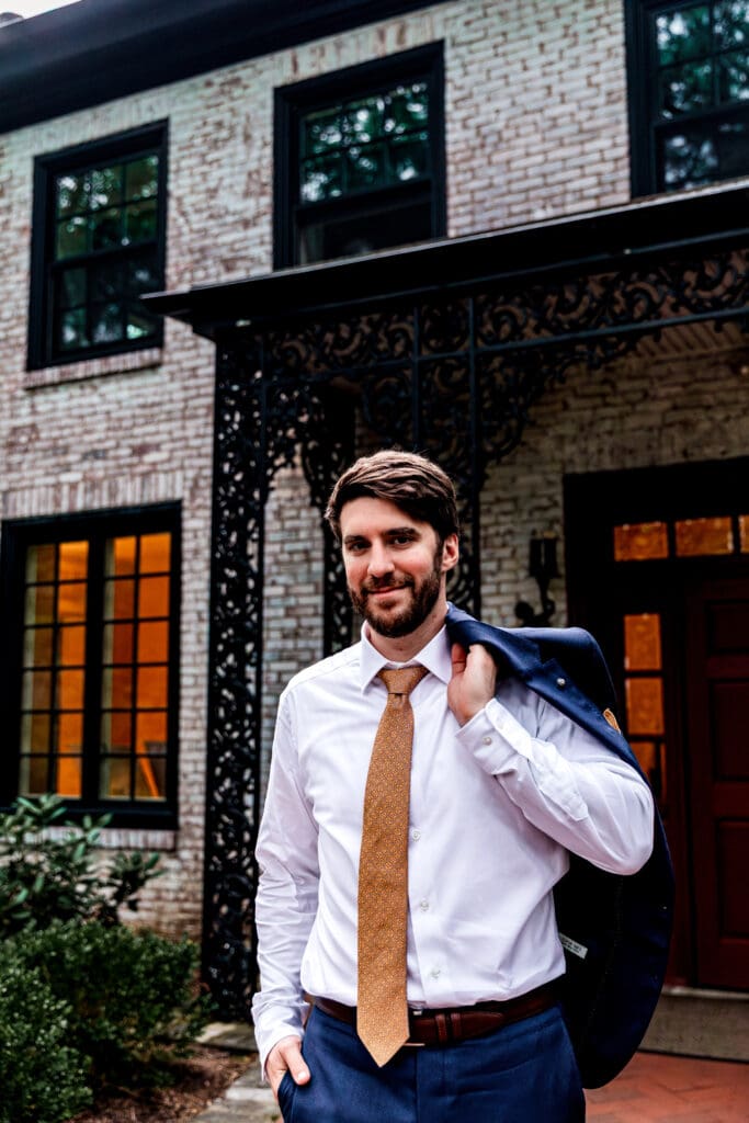 Groom posing and slinging jacket for wedding portraits at Succop Nature Park