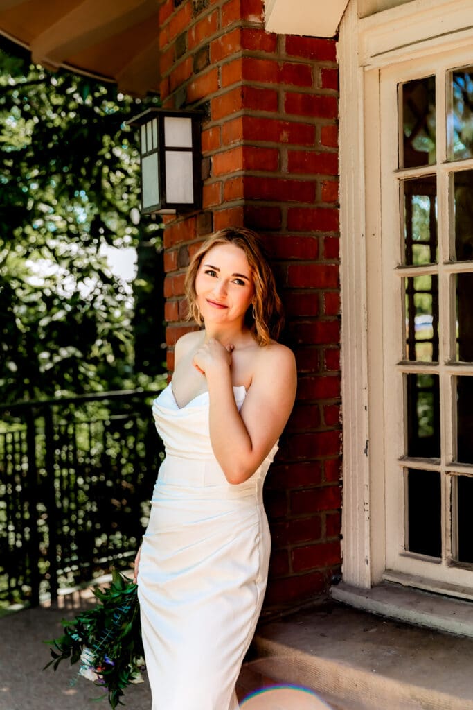 Bride leaning against a wall and gazing at her groom during portraits at Schenley Park Welcome Center