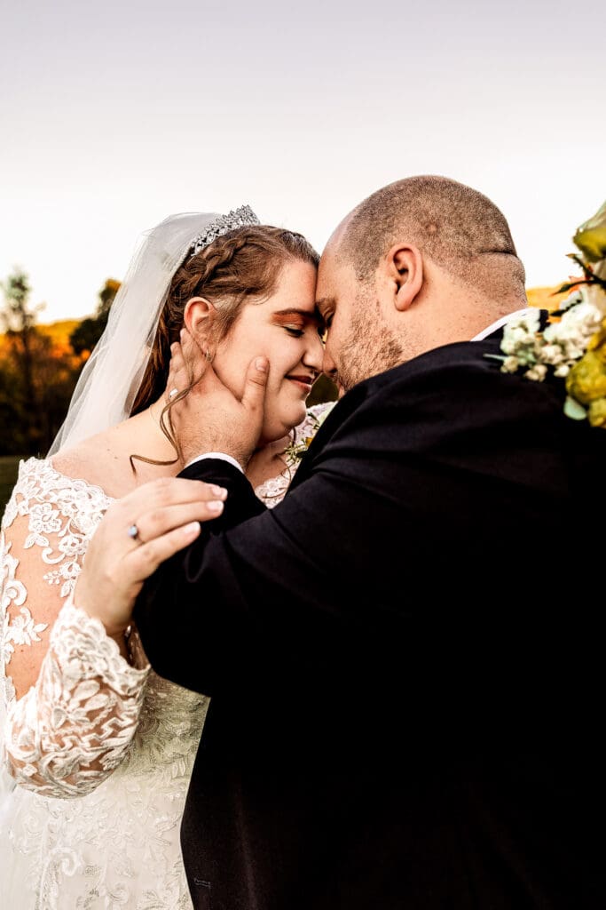 Close-up of bride and groom as groom tenderly caresses his bride’s face during fall Ridgemont Farms wedding in Beaver County
