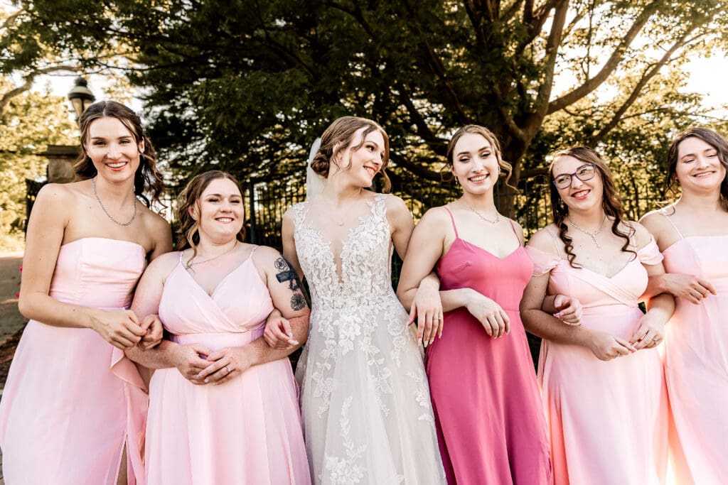 Bride and bridesmaids walking toward the camera laughing at a Pittsburgh Phipps Botanical Gardens wedding