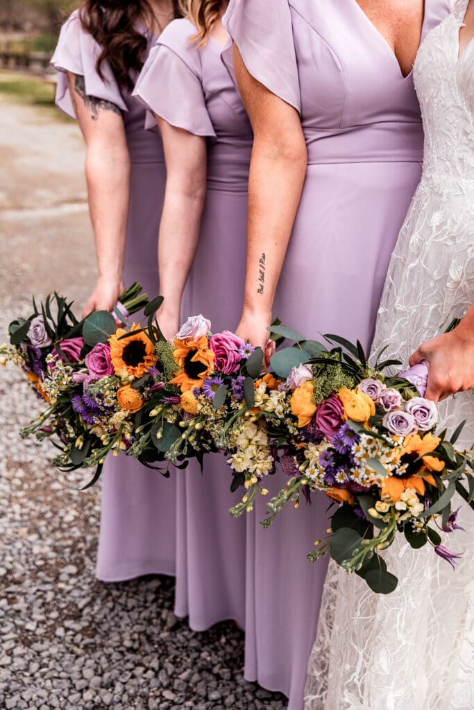 Vibrant wildflower wedding bouquet photographed near The Fez by a lake