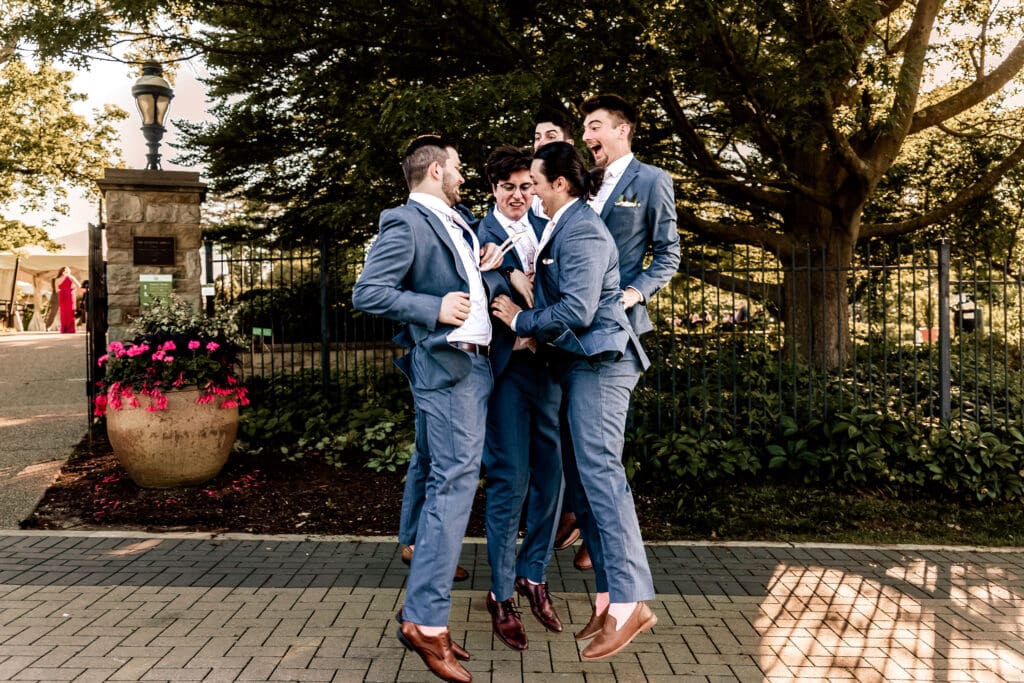 Pittsburgh groom and groomsmen jumping and celebrating together at a Phipps Botanical Gardens wedding