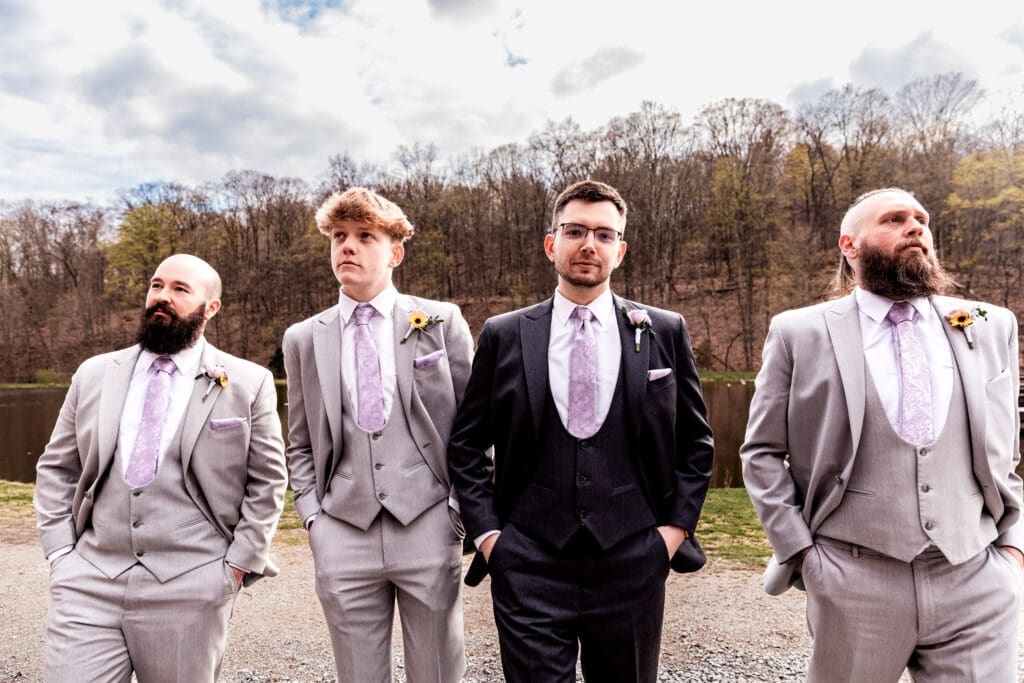Groomsmen walk towards camera in grey and purple ties at Hopewell Community Park near the The Fez