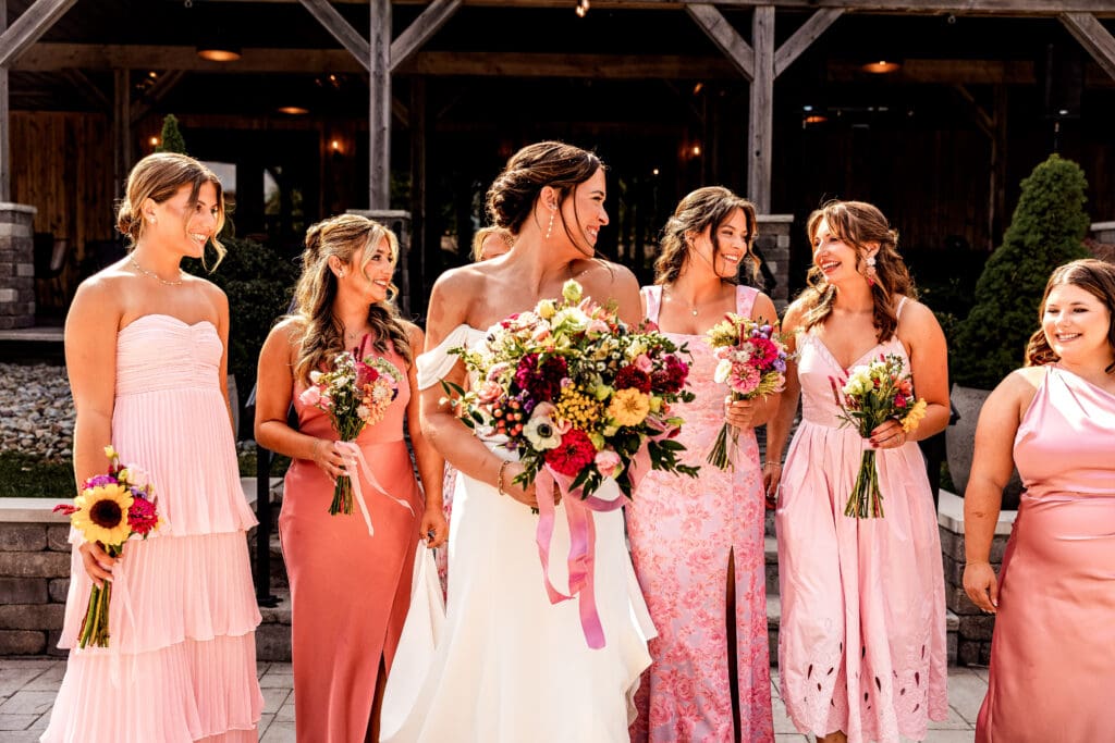 Bride and bridesmaids walking and laughing together during Willowbrook wedding portraits in Volant, PA