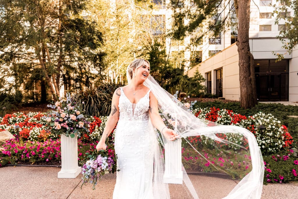 Pittsburgh bride holding her veil during garden portraits at Pittsburgh Airport Marriott wedding