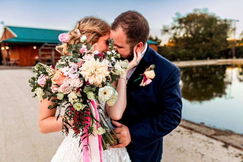 Pittsburgh wedding couple posing near water during portraits at The Gathering Place at Darlington Lake