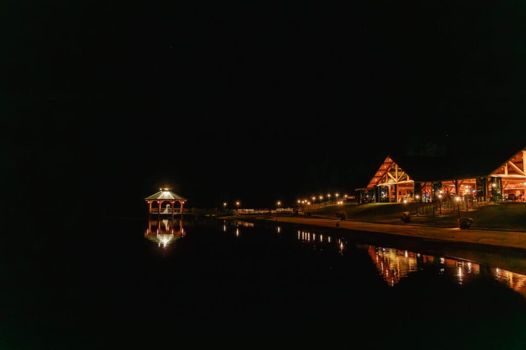 Nighttime photo of bride and groom across the lake under gazebo at The Gathering Place at Darlington Lake