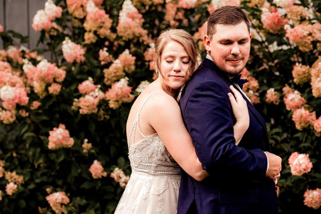 Bride hugging her groom from behind during portraits at The Barn at Ever Thine wedding in Fenelton, PA