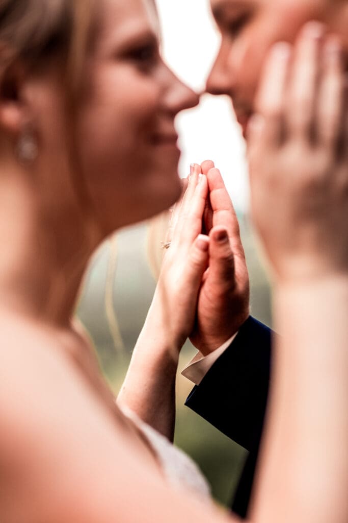 Close-up of bride and groom’s hands at sunset overlooking The Barn at Ever Thine in Butler County, PA