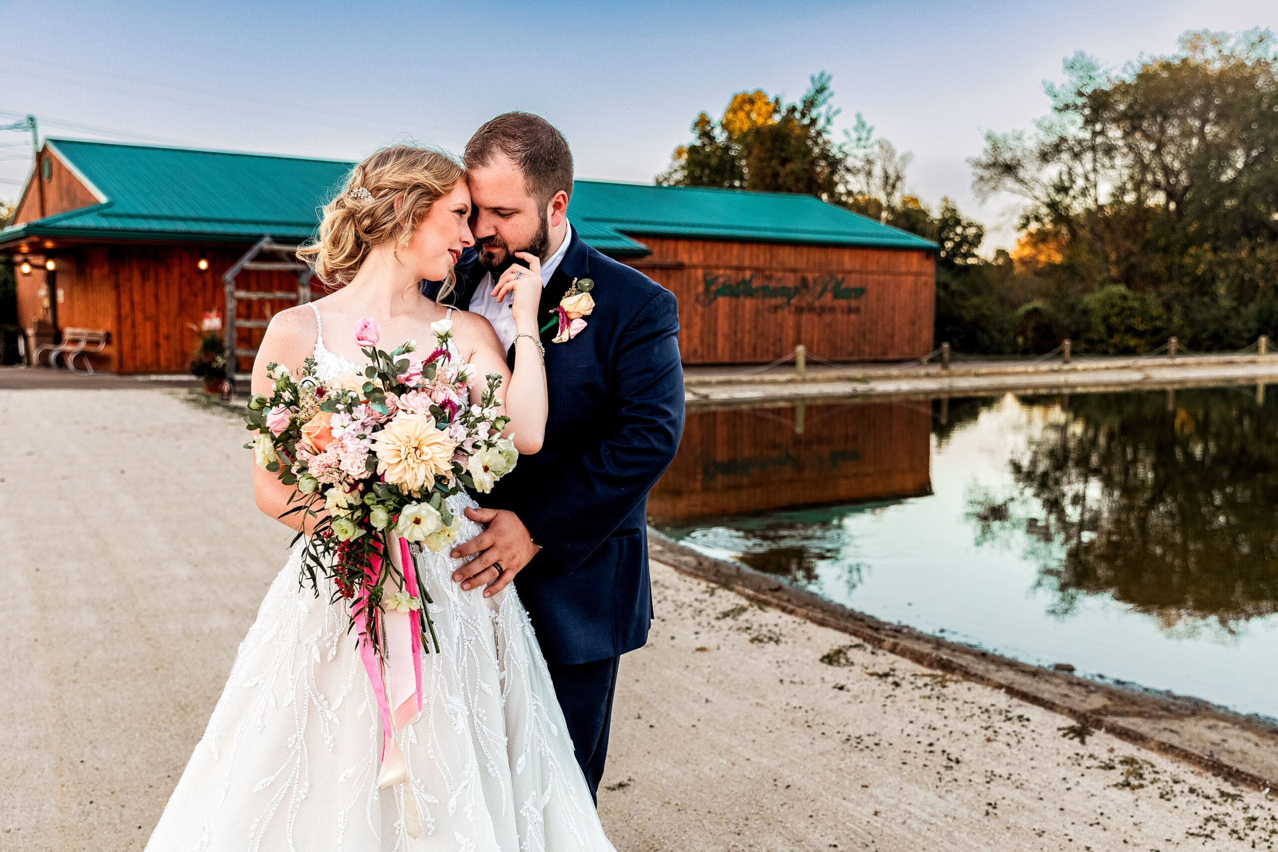 Pittsburgh wedding couple sharing an embrace by the lake at The Gathering Place at Darlington Lake
