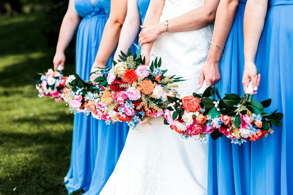 Bridesmaids in light blue dresses holding pink and peach bouquets at a Willowbrook wedding