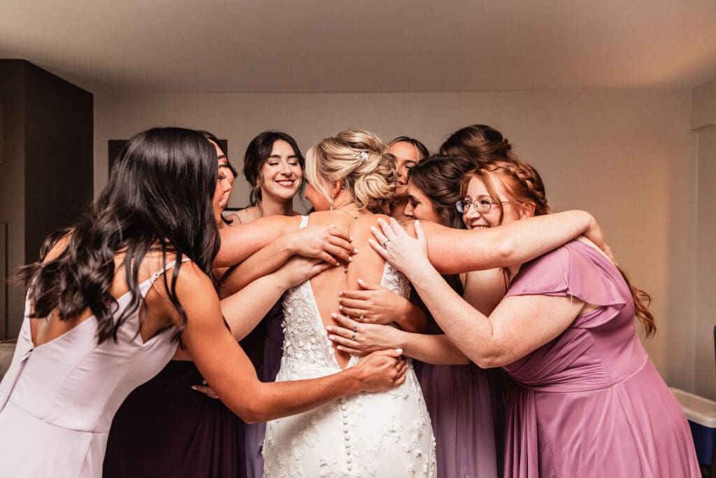 Pittsburgh bride embraces her bridesmaids after their first look at Pittsburgh Airport Marriott