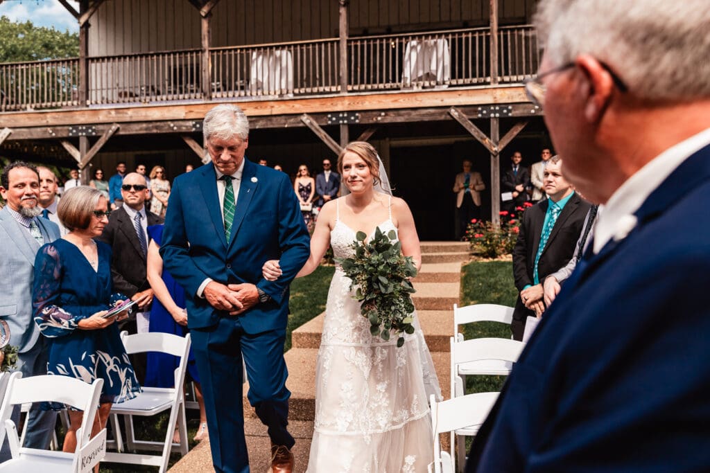 Bride escorted down the aisle by her father during the wedding ceremony at The Barn at Ever Thine in Butler County, Pennsylvania