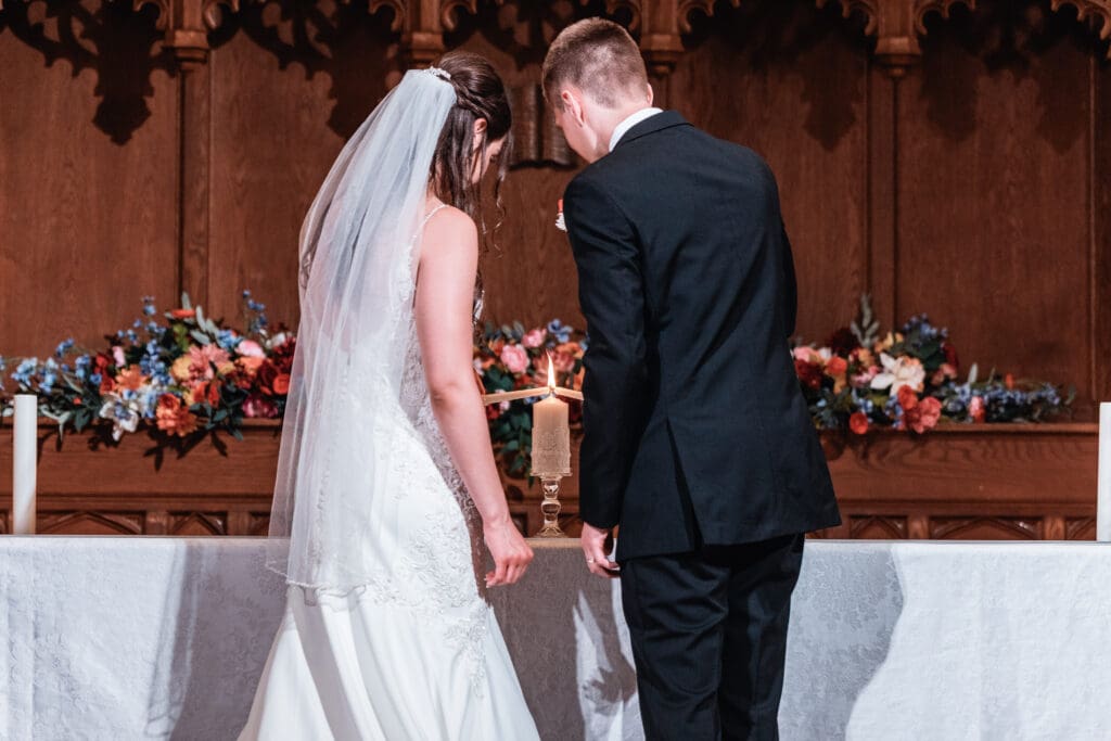 Couple lights a unity candle during their church wedding ceremony