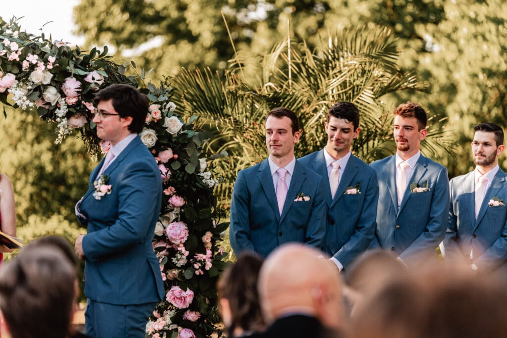 Groomsmen reacting emotionally as the couple exchanges vows at a Pittsburgh Phipps Botanical Gardens wedding