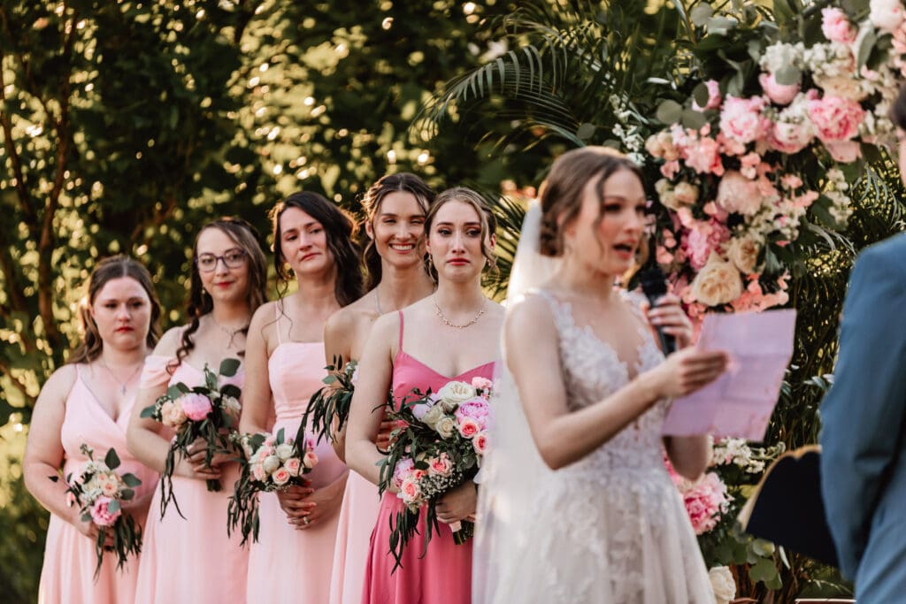 Bridesmaids holding back tears while couple reads vows at a Phipps Botanical Gardens wedding