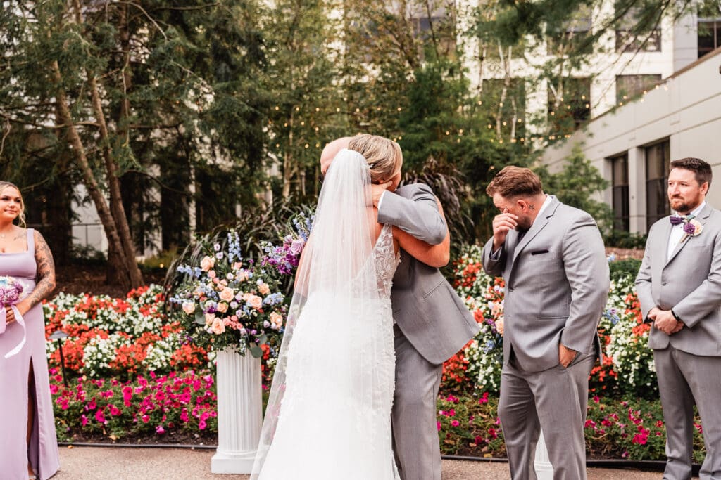 Pittsburgh bride embraces her father at the altar during Pittsburgh Airport Marriott ceremony