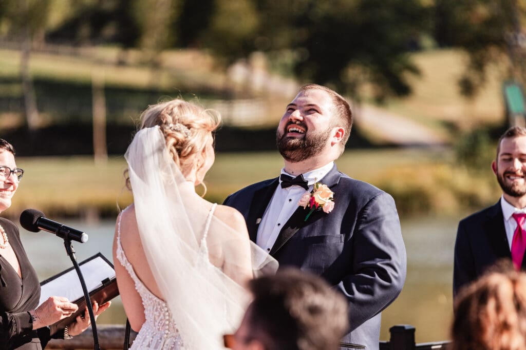 Bride and groom laughing together at the altar during ceremony at The Gathering Place at Darlington Lake