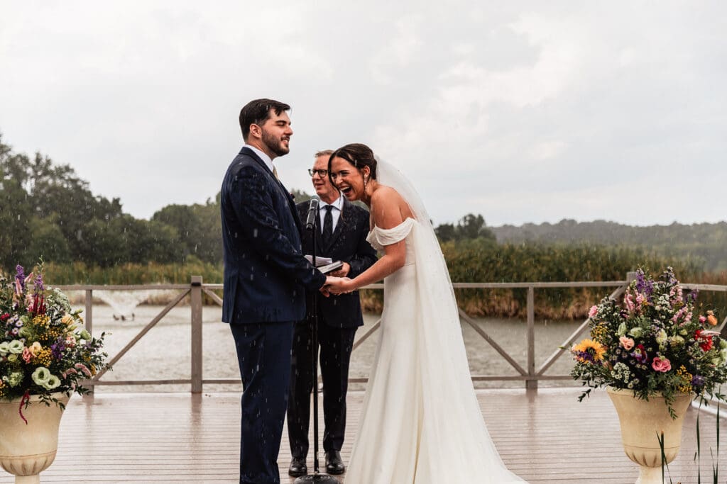 Pittsburgh couple laughs together as rain falls during their outdoor Willowbrook wedding ceremony in Volant, PA