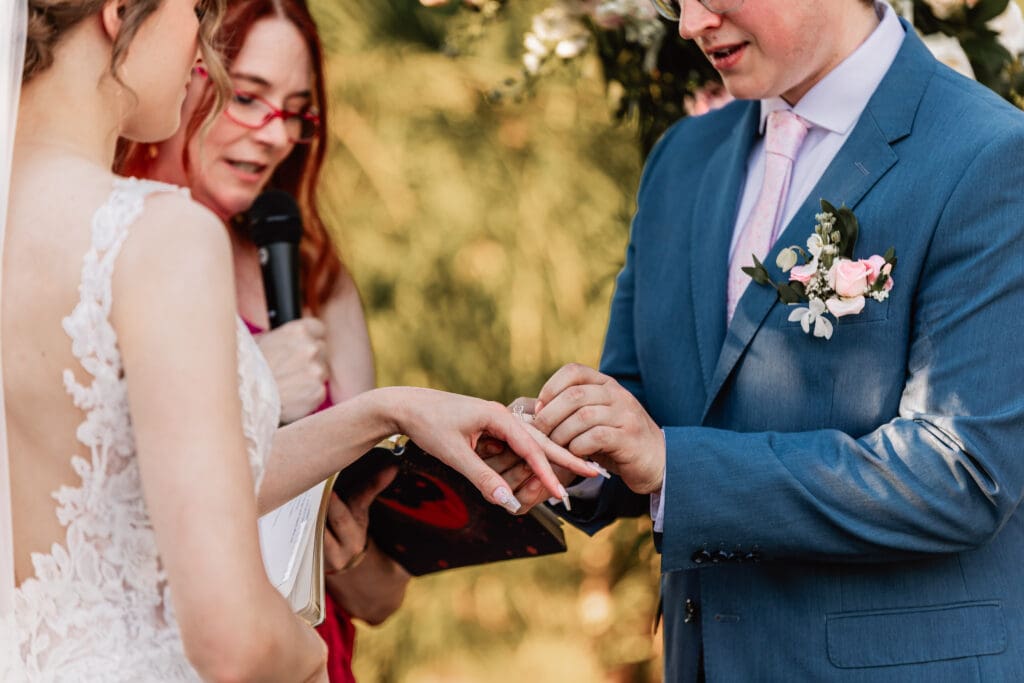Close-up of bride and groom exchanging rings at a Pittsburgh Phipps Botanical Gardens wedding