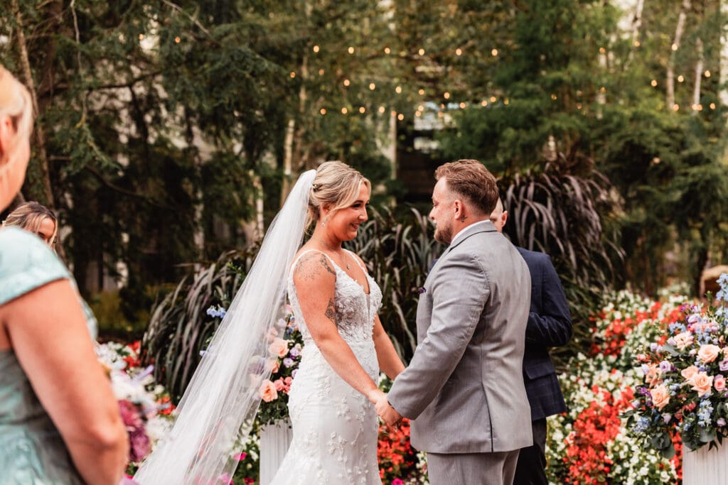 Bride and groom holding hands and smiling at the altar during Pittsburgh Airport Marriott wedding