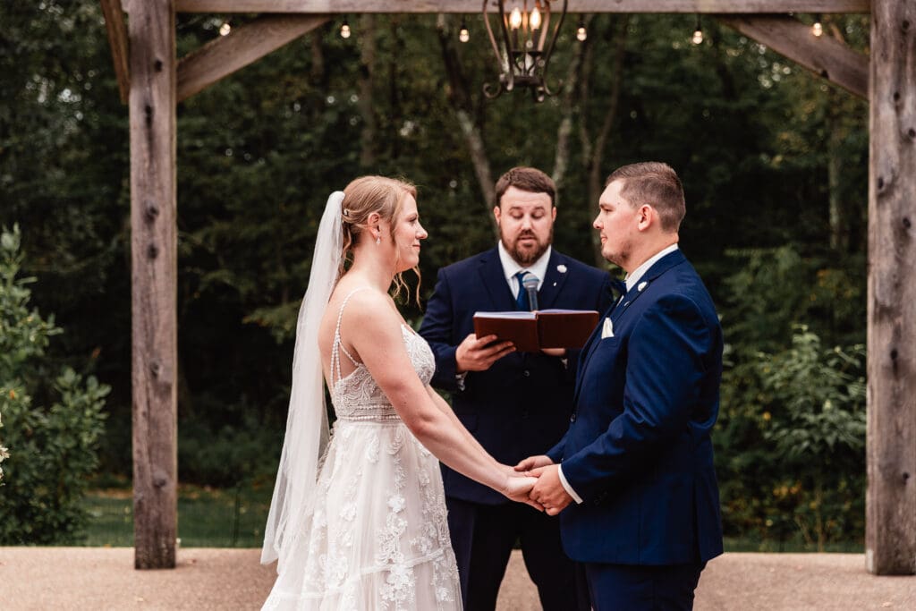 Bride and groom exchanging vows during their wedding ceremony at The Barn at Ever Thine in Butler County, PA