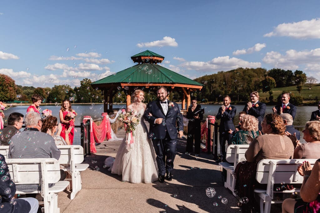 Bubbles surround the newlyweds as they walk down the aisle at The Gathering Place at Darlington Lake