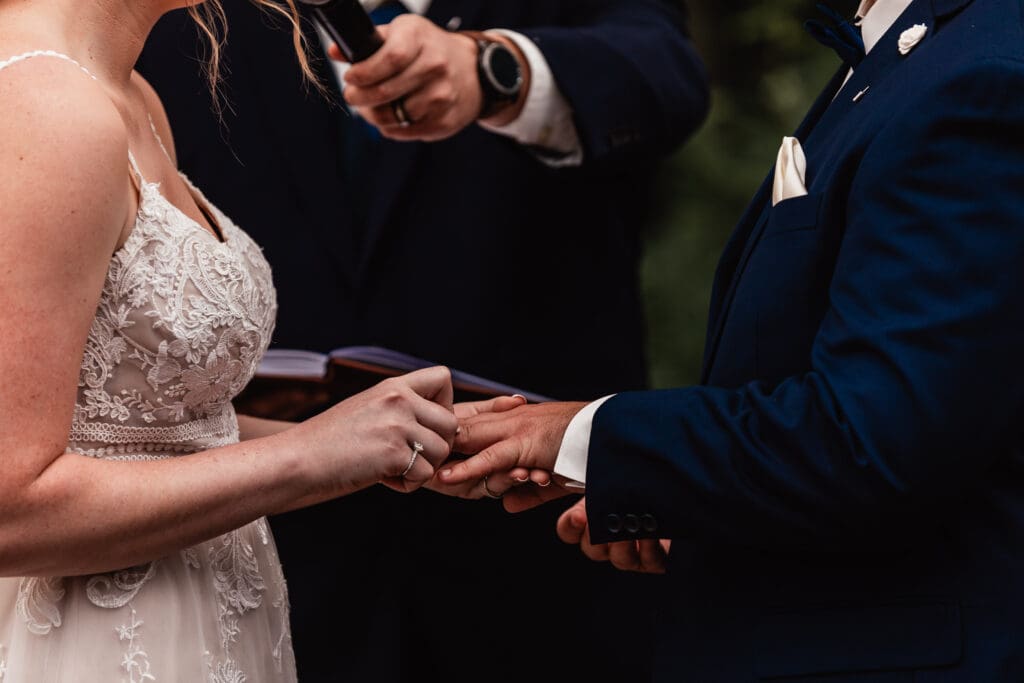 Close-up of bride and groom exchanging rings during their ceremony at The Barn at Ever Thine in Fenelton, Pennsylvania