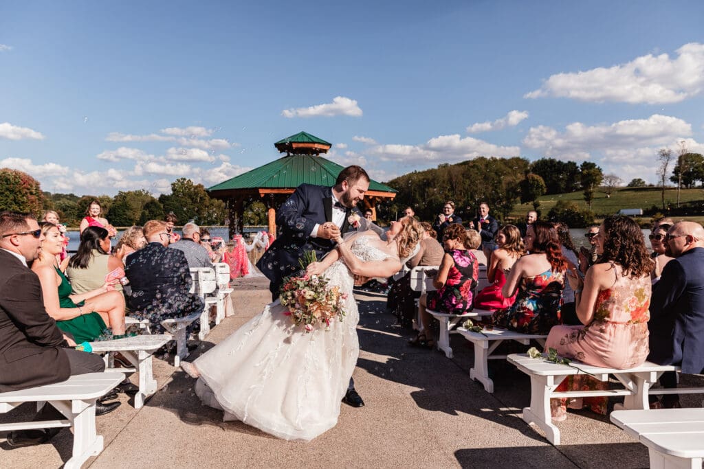 Bride and groom recessing down aisle surrounded by bubbles at The Gathering Place at Darlington Lake wedding