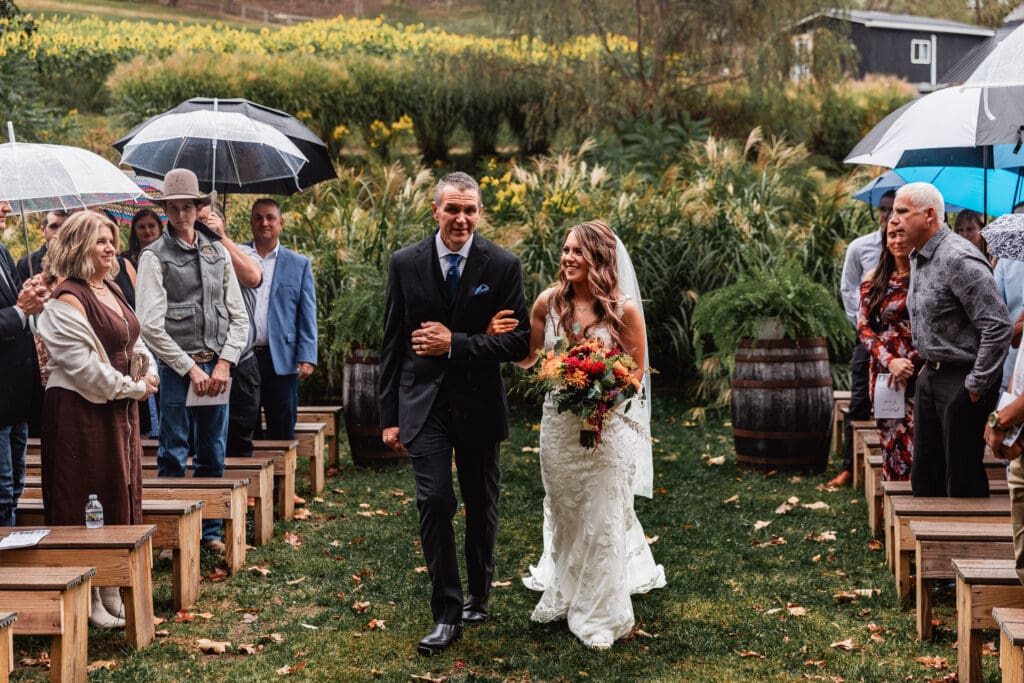 Bride escorted by her father during ceremony at Hinckston Run Farm